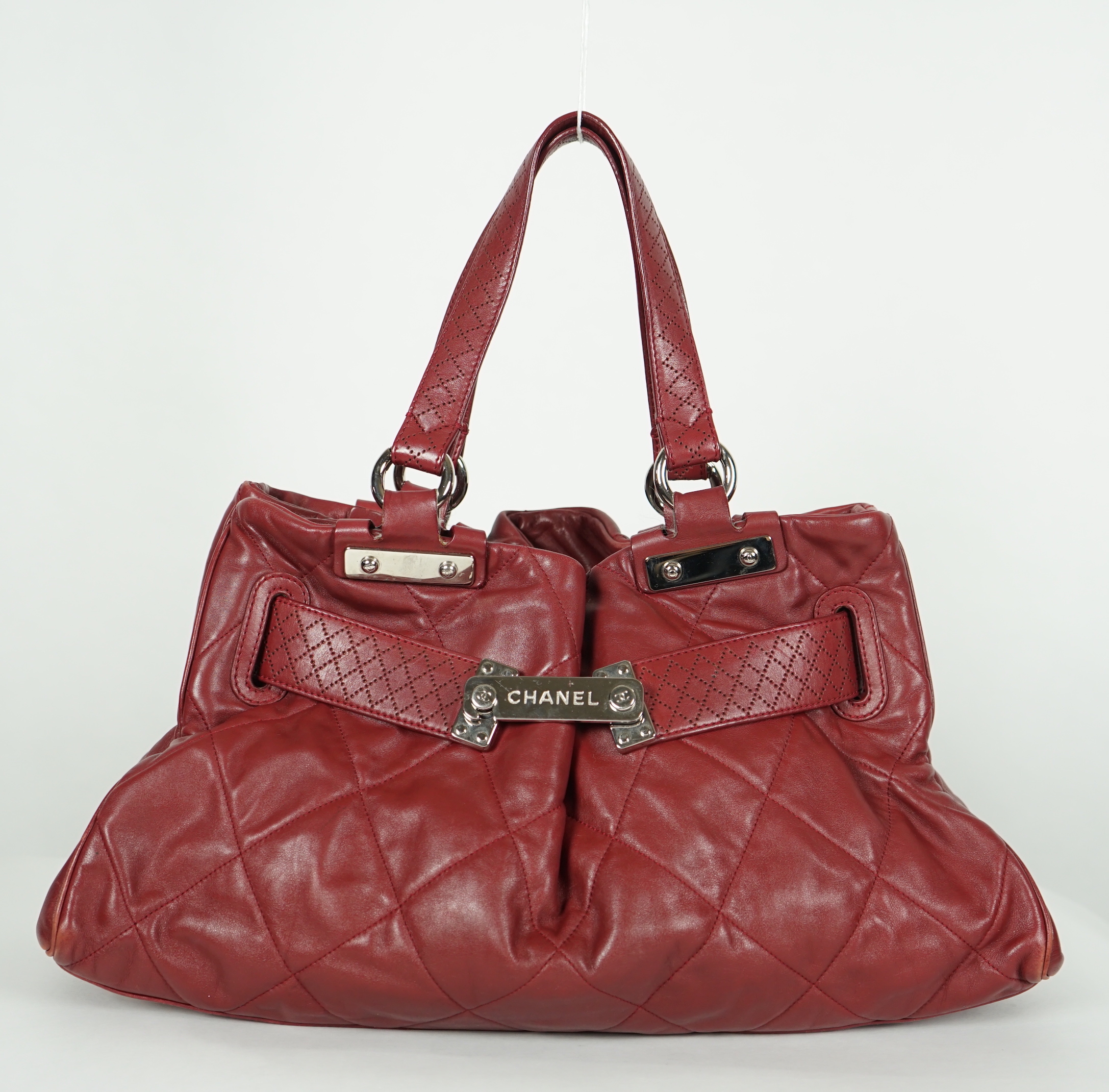 A Chanel burgundy leather buckled handle bag, with dust bag, width 45cm, height: 24.5cm, height overall 44cm, depth 16.5cm, Please note this lot attracts an additional import tax of 20% on the hammer price